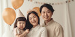 © iuricazac - Happy Asian family and child celebrate a studio birthday. Generative AI