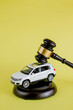 Car auction concept - gavel and car key on yellow background. Accident lawsuit or insurance, court case.