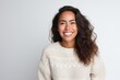 © Anne Schaum - Medium shot portrait photography of a Peruvian woman in her 30s wearing a cozy sweater against a white background