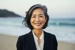 © Anne Schaum - Portrait photography of a Vietnamese woman in her 50s wearing a sleek suit against a beach background