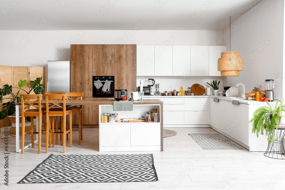 Interior of light kitchen with modern appliances on wooden table
