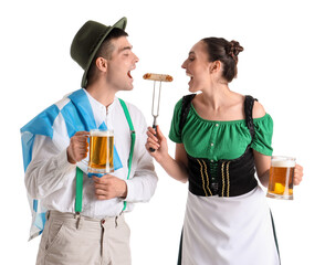 Young couple in traditional German clothes with beer and sausage on white background