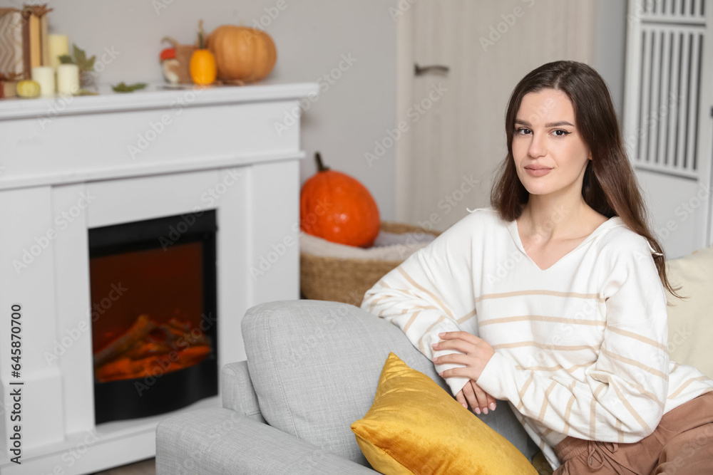 Young woman sitting on sofa at home