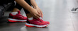 © NT_studio - Closeup young woman tying shoelace with hands for jogging in fitness gym sport club, female preparing workout and exercise with wearing sportswear and sneaker, healthcare and motivation.