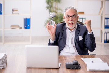 Old male employee holding star award