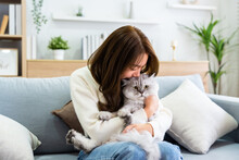 Portrait Of Young Asian Woman Holding Cute Cat. Female Hugging Her Cute Long Hair Kitty. Adorable Pet Concept