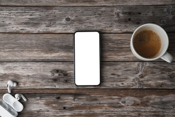 Wall Mural - Mobile phone on wooden table showing blank screen, shot from abo