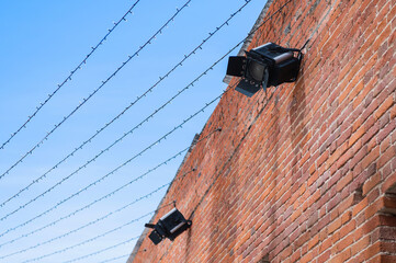 spotlights for artistic illumination are installed on the exterior wall of the building. garlands with diode lamps are stretched across the street forming a light canopy