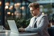 © artsterdam - Pensive businessman using laptop at workplace. A man in a suit works at a computer in the office. Generative AI
