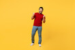 Full body young overjoyed happy Indian man wears red t-shirt casual clothes doing winner gesture celebrate clenching fists say yes isolated on plain yellow orange background studio. Lifestyle concept.
