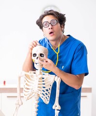 Wall Mural - Funny doctor with skeleton in hospital