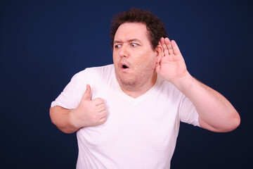 Wall Mural - Funny fat man posing in the studio. Blue background.