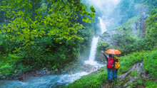 Lover Asian Man And Asian Women Travel Nature Travel The Highest Waterfall In Chiangmai Mae-pan Waterfall Rainy Season At Doi Intanon.