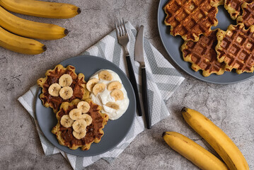 Wall Mural - Healthy lifestyle. Healthy breakfast: banana waffles with Greek yogurt. Serving breakfast for one person. Reasonable consumption: waffles from overripe bananas.