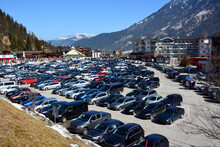 A Large Car Park In A Ski Resort With Rows Of Various Cars Of Holidaymakers
