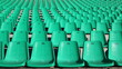 fragment of a stadium tribune with rows of green plastic chairs without people, like a city background, unoccupied seats for fans in the sector for watching sports competitions, city infrastructure
