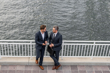 Wall Mural - Colleague discuss. Business man talking on outdoor meeting. Devising big plans with the boss. Business partners are discussing, teamwork and chatting outdoor. Business man sharing business idea.