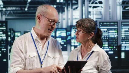 Poster - colleagues in data center using laptop to monitor energy efficient rigs. server farm using renewable