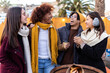 © Xavier Lorenzo - Diverse group of people having fun together at christmas market in winter. Multiracial young adult men and women enjoying time together drinking hot drink during travel vacation