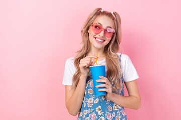 Poster - Photo of good mood dreamy woman dressed flower print overall in sunglass look empty space hold soda cup isolated on pink color background