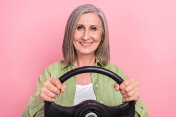 Canvas Print - Photo of cheerful lovely senior lady pensioner wear green trendy clothes drive car first time city roads isolated on pink color background