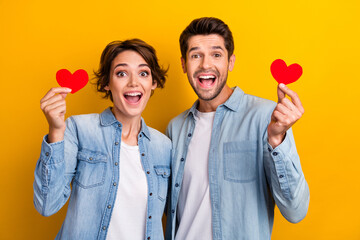 Aufkleber - Photo of surprised cheerful people wear trendy jeans clothes hold red paper card celebrate honeymoon isolated yellow color background