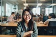 © NikoG - Smiling portrait of a happy young asian woman working for a modern startup company in a business office