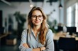 © NikoG - Smiling portrait of a happy young caucasian woman working for a modern startup company in a business office