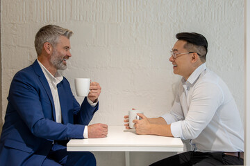 Wall Mural - Businessman take break drinking coffee and discussing business strategy in office.