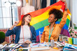 © kelvn - Cheerful young woman with lgbt flag smiling.