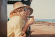 © luciano - Smiling optimist couple of senior and middle age women with hats make confidences while drink a coffee cup. Two female friends enjoying freedom and relax in outdoors