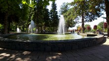 Fountains On City Park In A Hot Summer Day Cooling The Ambient In Park Frequented By Elderly And Kids