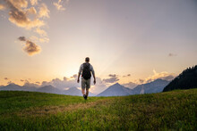 Hiker exploring in meadow at sunset