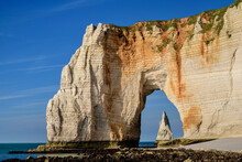 Chalk Cliffs With Natural Arch On Sunny Day Under Blue Sky