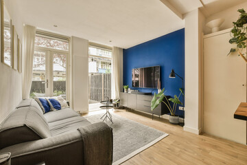 a living room with blue walls and white trim on the walls, hardwood flooring in the center of the room