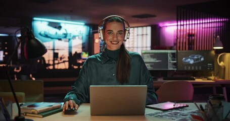 Aufkleber - Zoom in Portrait of a Beautiful Manager Sitting at a Desk in Creative Agency, Using Laptop Computer. Young Stylish Female with Headphones Looking at Camera with Big Smile While Working on New Project