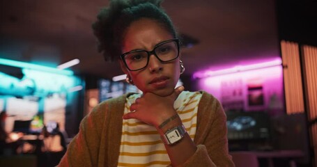 Aufkleber - Zoom in: Stylish Young Black Woman Looking at Camera With Confusion While Working on Desktop Computer in Creative Office. Female Developer Trying to Fix a Bug, Unsure of the Source of the Issue