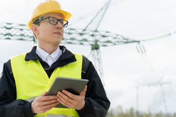 Poster - Engineer with digital tablet on a background of power line tower.