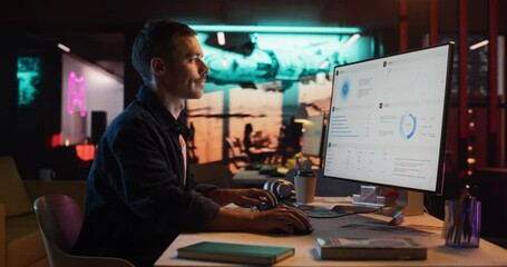 Poster - Talented Male Digital Marketing Specialist Working on Computer at Office in the Evening. Young Caucasian Businessman in Creative Agency, Smiling and Researching Business Analytical Data