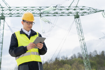 Poster - Engineer with digital tablet on a background of power line tower.