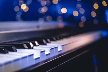 Wall Mural - Piano keys close-up on a blurred background with bokeh.