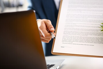 Male arm in suit offer contract form on clipboard pad and silver pen to sign closeup. Strike a bargain for profit white collar motivation union decision corporate sale insurance agent concept