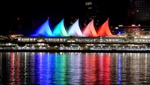 4k CANADA PLACE Sails Of Light At Night Reflecting On Water, Downtown Vancouver British Columbia, Seen From Stanley Park Sea Wall. Home Of The 2010 Olympic Games.