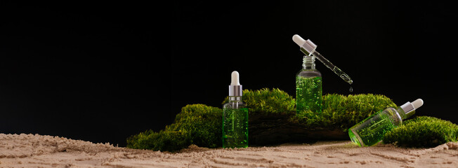 Wall Mural - banner bottle of cosmetic serum on natural background with moss organic cosmetics