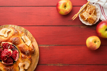 Wall Mural - Jewish Holidays - Rosh Hashanah or Rosh Hashana. Pomegranate, apples, honey and round challah on  old wooden red table background. Jewish Autumn celebration. Shana Tova. Yom kippur concept. Top view