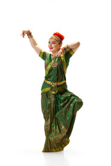 Wall Mural - Beautiful woman in green dress dancing traditional indian dance bharatanatyam against white studio background. Concept of beauty, fashion, India, traditions, lifestyle, choreography, art. Ad