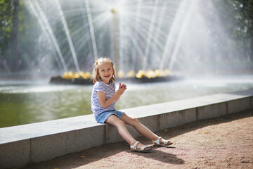 Wall Mural - Adorable preschooler girl walking in Petergof, St. Peterburg, Russia