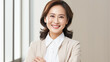 © BlazingDesigns - Smiling asian confident businesswoman with arms crossed standing in the office. Smiling mature confident professional executive manager, proud lawyer, confident businesswoman leader.