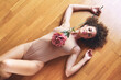 © VISTA by Westend61 - Beautiful woman holding flower and lying on hardwood floor
