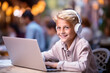 © pariketan - A Boy blonde student smile online learning using laptop and headset